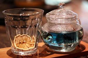 een glas blauwe thee met sinaasappelgarnituur foto