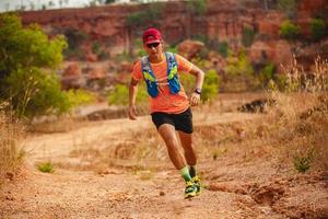 een man loper van het spoor. en atleetvoeten die sportschoenen dragen voor trailrunning in de bergen foto