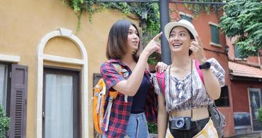 Aziatische vrouwenrugzakken die samen en gelukkig lopen, nemen foto's en zien er uit, ontspannen tijd op vakantieconceptreizen foto
