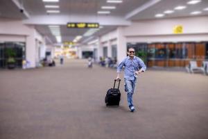 Aziatische man reiziger met koffers wandelen en vervoer op een luchthaven foto
