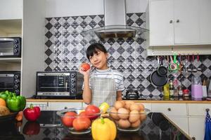 gelukkige familie en hun dochtertje koken samen in de keuken foto