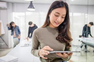 Aziatische vrouwelijke studenten glimlachen en hebben plezier en het gebruik van een smartphone en tablet helpt ook om ideeën te delen in het werk en het project. foto