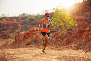 een man loper van het spoor. en atleetvoeten die sportschoenen dragen voor trailrunning in de bergen foto