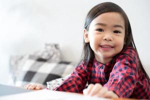 Aziatisch schattig klein meisje zittend lachend foto