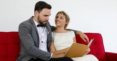 de geliefden geven bloemen aan de bruid en kusten gelukkig en het paar houdt van staande in de trouwstudio foto