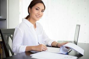 Aziatische zakenvrouwen die een notitieboekje gebruiken en glimlachen, blij om te werken foto