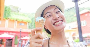 mooie vrouw die ijs vasthoudt en eet op zomervakantie foto