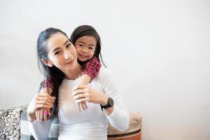 de dochter knuffelt haar moeder en lacht gelukkig foto