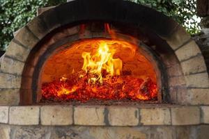brandend brandhout in een oven, sintels, gloeiende kolen. foto