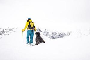 tijdens een sneeuwschoenwandeling kijkt een hond naar zijn minnares foto