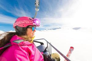 jonge sportieve meisje skiër stoeltjeslift naar skigebied foto