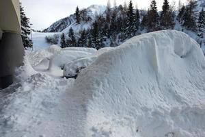 auto's bedekt met sneeuw na grote sneeuwval op de alpen foto