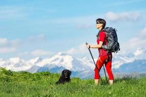 meisje oefent trekking in de bergen met zijn herdershond foto