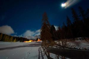 huizen in de sneeuw op een sterrennacht met de maan foto