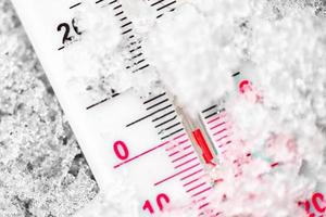 thermometer markeert de nul graden in de kou in de sneeuw foto