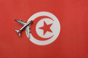 het vliegtuig boven de vlag van tunesië, het concept van reizen. foto