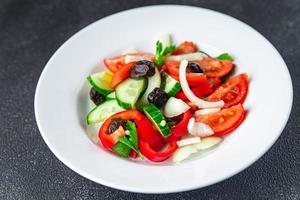 verse groentesalade tomaat, komkommer, paprika, ui, zwarte olijven keto of paleodieet foto