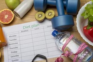dieetplan, menu of programma, roulette, water, halters en dieetvoeding met vers fruit op houten vloer. foto