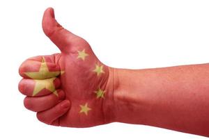 het concept van een china-hand geeft een duim omhoog met de vlag van china. foto