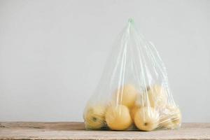gele appels in een plastic zak op een houten tafel. kopiëren, lege ruimte voor tekst