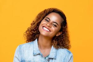 portret van mooie Afro-Amerikaanse vrouw die lacht geïsoleerd op gele achtergrond foto