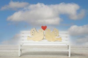 een paar duiven met een hart op een witte bank. liefde concept, close-up met kopie ruimte. foto