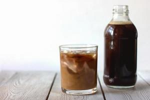 iced cold brew koffie in een fles en in een glas. CBD-concept. foto
