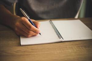 man hand met pen schrijven op notebook. foto