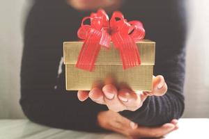 cadeau geven, man hand met een geschenkdoos in een gebaar van Giving.blurred achtergrond, vintage effect foto