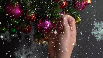 groet seizoen concept.hand instelling van ornamenten op een kerstboom met decoratief licht foto