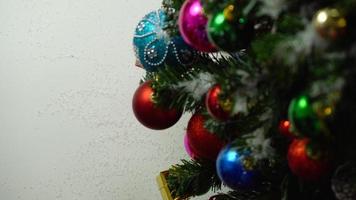 groet seizoen concept.hand instelling van ornamenten op een kerstboom met decoratief licht foto