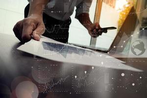 close-up van de hand van de zakenman die op een laptop werkt met een bedrijfsgrafiekinformatiediagram op een houten bureau als concept foto