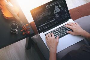 hipster hand componeren van muziek met laptop compter en zittend op de bank thuis studio foto