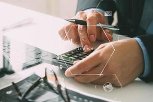 close up van zakenman hand werken met financiën over kosten en rekenmachine en laptop met mobiele telefoon op met bureau in modern kantoor foto