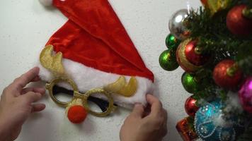 groet seizoen concept.hand instelling van ornamenten op een kerstboom met decoratief licht foto