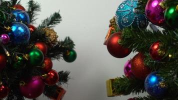 groet seizoen concept.hand instelling van ornamenten op een kerstboom met decoratief licht foto