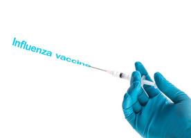 hand in een blauwe handschoen met spuit met griepvaccintekst op wit wordt geïsoleerd foto