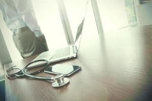 arts die op de werkruimte werkt met een laptop in een medisch werkruimtekantoor en een medisch netwerkmediadiagram als concept foto