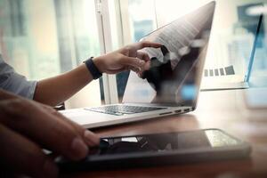 designer hand werken en slimme telefoon en laptop op houten bureau in kantoor met Londen stad achtergrond foto