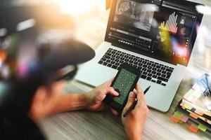 designerhand die videoconferentie bijwoont met laptop en smartphone aan de balie op kantoor foto