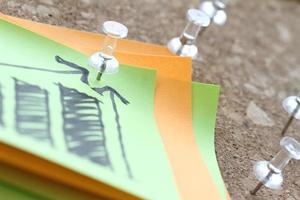 close-up van pin en met de hand getekende zakelijke strategiegrafiek op kleverige nota met kurkbord als concept foto