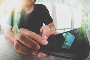 designer hand werken en slimme telefoon op houten bureau in office foto