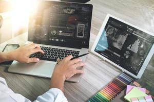 zakenman hand bijwonen van videoconferentie met laptopcomputer en tablet comouter aan balie in kantoor foto