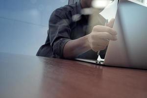 zakenman hand werken met nieuwe moderne computer en slimme telefoon en bedrijfsstrategie op houten bureau als concept foto