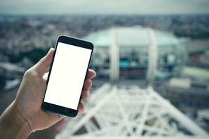 man hand met leeg scherm smartphone tegen london city wazig achtergrond foto