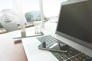 zakelijke documenten op kantoor tafel met slimme telefoon en digitale tablet als werkruimte bedrijf met leeg scherm computer laptop foto