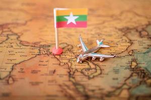 Myanmar vlag en vliegtuig op de wereldkaart. foto
