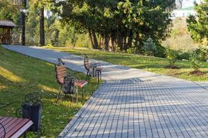 nieuwe lichte brawn bank in park in de buurt van de steeg in het herfstseizoen bij rustig weer foto