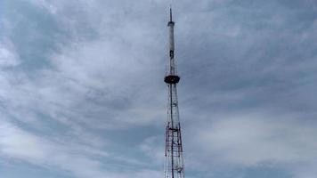 telecommunicatie toren blauwe wolken op blauwe hemelachtergrond foto