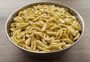 traditionele ongekookte italiaanse cavatelli. cavatelli is een soort korte pasta die typisch is voor Zuid-Italië, alleen bereid met griesmeel en water. foto